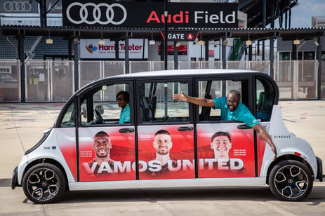 United Soccer branded Circuit Shuttle posed in front of Audi Field