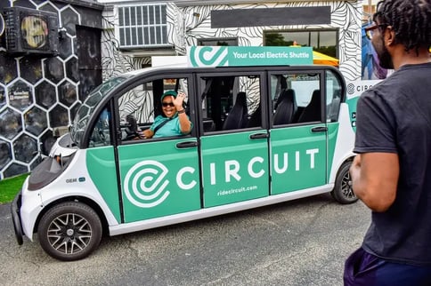 Circuit Driver Embassador Waving from Circuit Branded GEM Vehicle